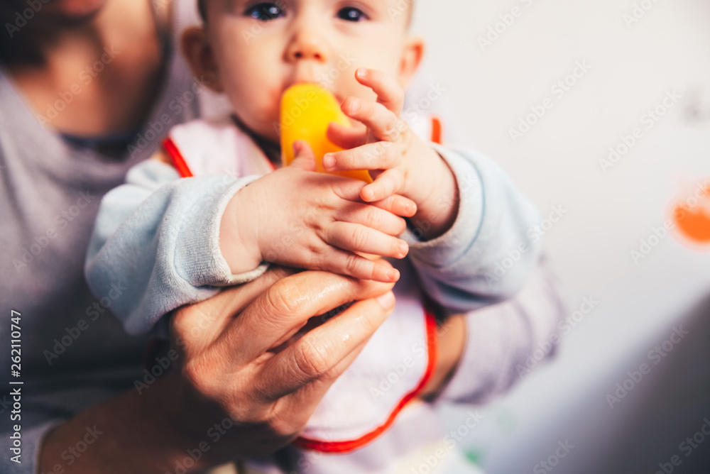 Baby savoring an orange ice cream. - obrazy, fototapety, plakaty 
