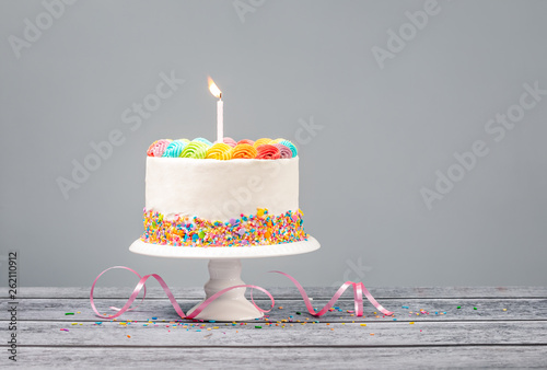 White Birthday Cake with one Candle and Colorful Icing