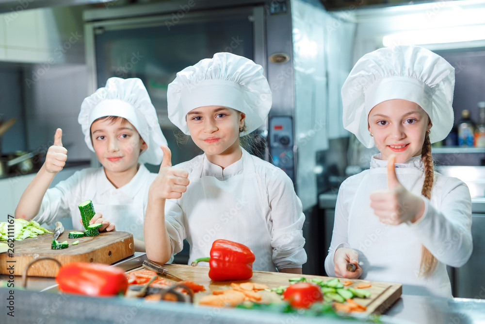 Children grind vegetables in the kitchen. Children grind vegetables in the kitchen.