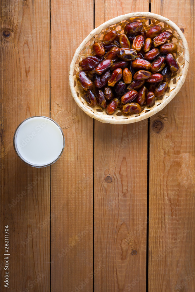 Dried dates and milk on wooden background. Holy month of Ramadan, concept. Righteous Muslim lifestyle. Starvation. Dates in a wooden basket in the style of minimalism. Copy space Dried dates and milk on wooden background. Holy month of Ramadan, concept. Righteous Muslim lifestyle. Starvation. Dates in a wooden basket in the style of minimalism. Copy space