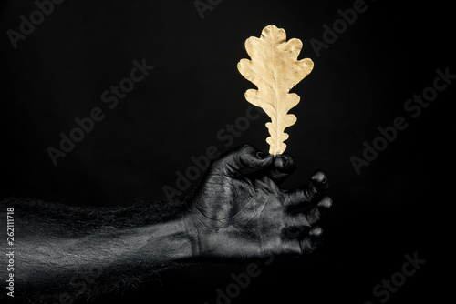 the hand is completely black paint with a yellow oak leaf