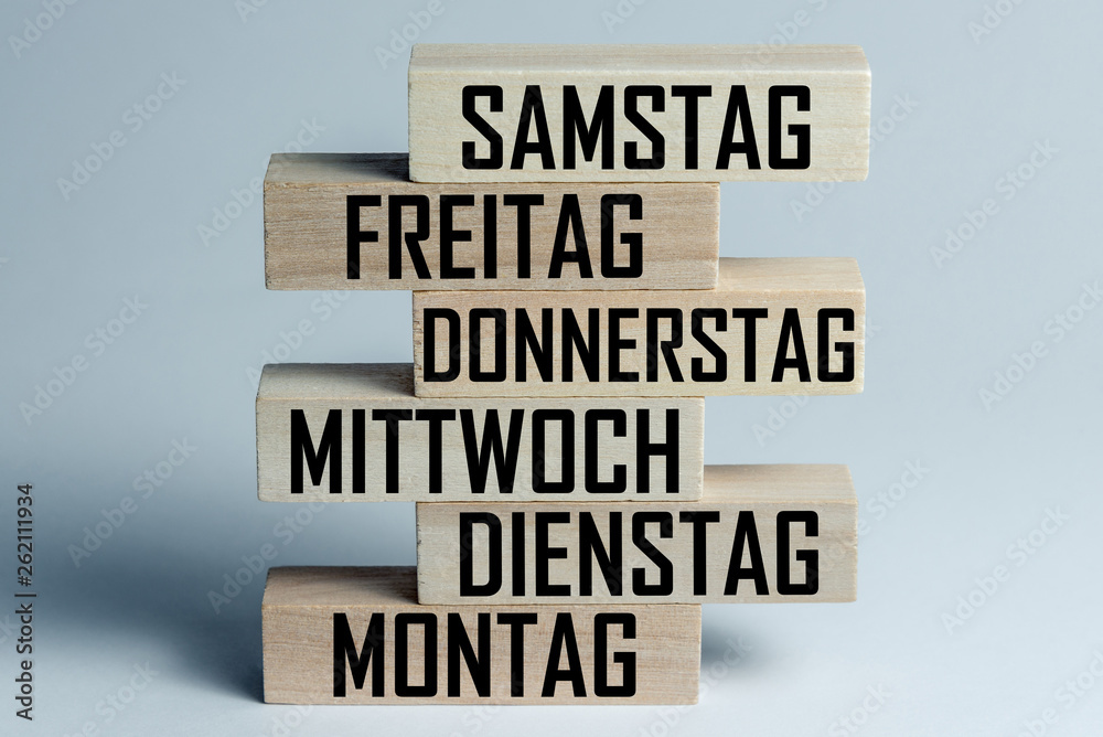 A list of wooden blocks lying on top of each other with a list of days of the six-day work week in German, in the translation of the word: saturday, friday, thursday, wednesday, tuesday, monday