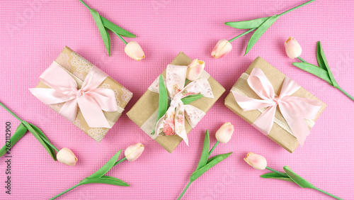 Gifts wrapped in kraft paper and pink ribbons overhead flat lay for Mother's Day, birthday or Valentine's Day celebrations. © millefloreimages