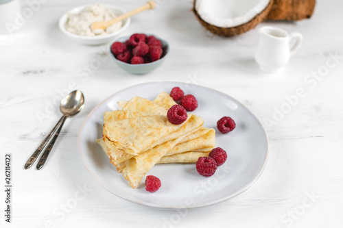 Morning, breakfast - traditional russian blini pancakes, french crepes served with fresh raspberries, coconut