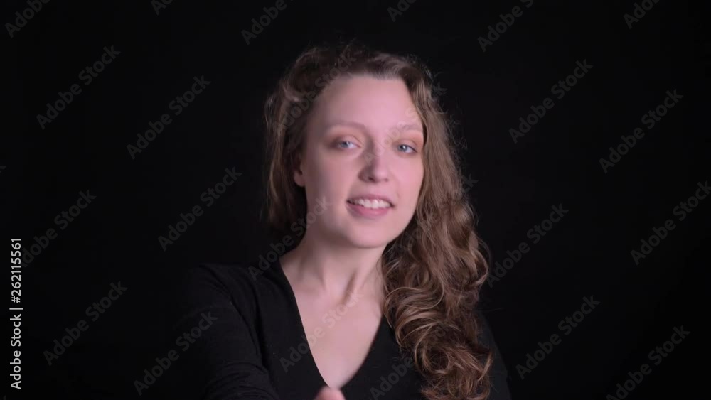 Portrait of young curly-haired girl gesturing finger-up showing like and respect into camera on black background. Portrait of young curly-haired girl gesturing finger-up showing like and respect into camera on black background.