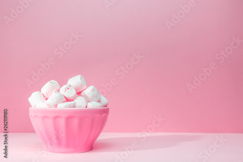 Pink bowl of giant marshmallows on pink backdrop with harsh shadows