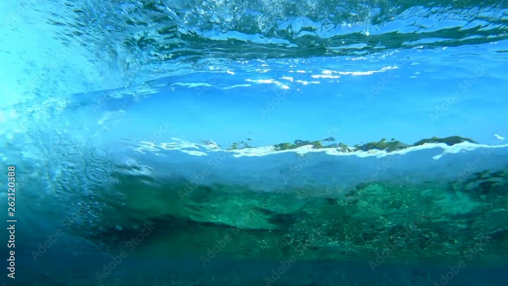 Underwater view of the tropical crystal clear brekaing wave working like a big lens and refracting the coast view Underwater view of the tropical crystal clear brekaing wave working like a big lens and refracting the coast view
