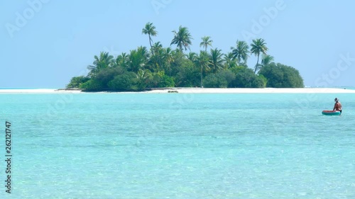 Coconut palms over a tiny, exotic island paradise with white sand beaches photo