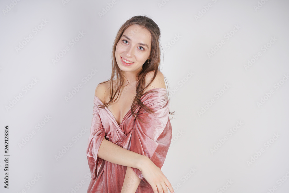 cute young caucasian teenager girl in pink velvet dress stands and smiles on white background in Studio cute young caucasian teenager girl in pink velvet dress stands and smiles on white background in Studio