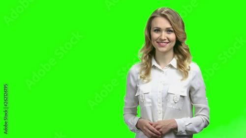 Young charming woman presenting something on green screen. Pretty caucasian woman presenting the weather forecast. Chroma Key background.