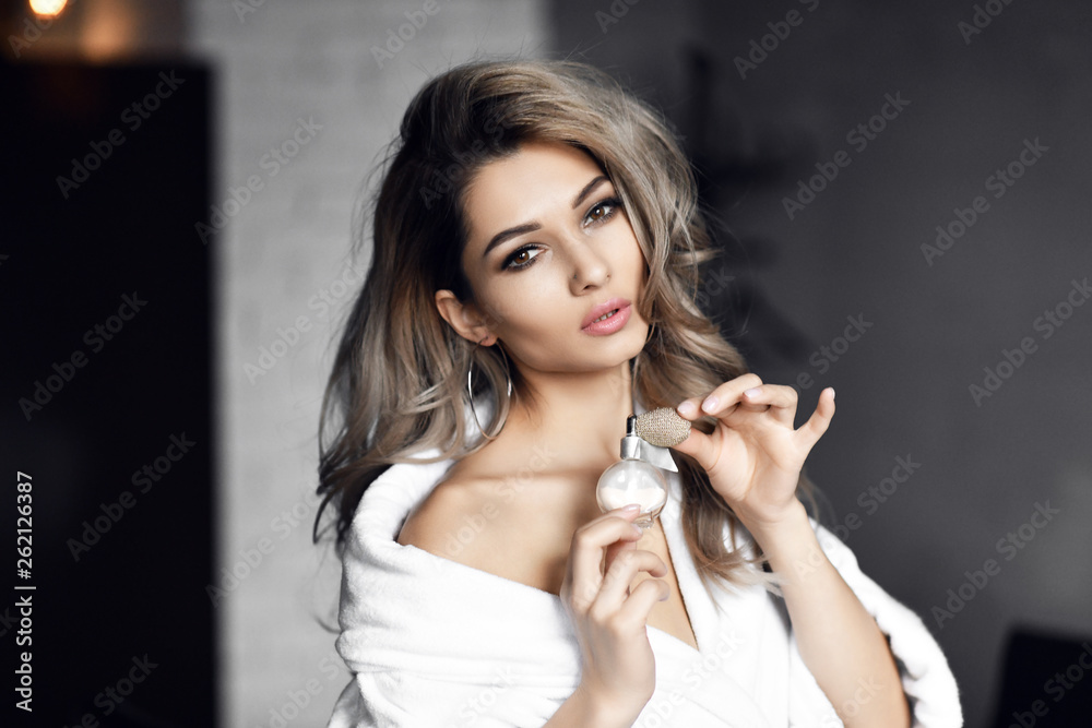 Beautiful young woman with bottle of perfume at home Beautiful young woman with bottle of perfume at home