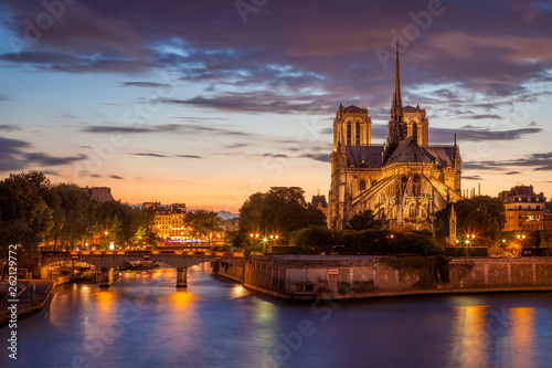 Notre Dame and the Seine at dusk with lights on