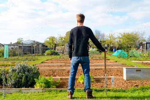 Male gardener at allotment with work tools