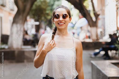 Portrait of a Latin girl or Hispanic female wearing sunglasses in a colonial city in Mexico summer © Marcos
