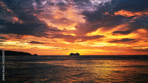 dramatic sunset skyline with seascape and travel cruise ship