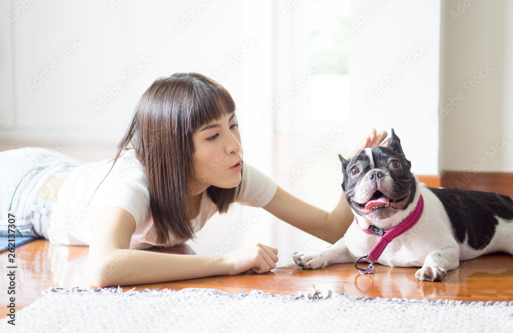 gentle girl in Casual wear with a pug puppy in the bedroom on the floor, bright daylight and light toning gentle girl in Casual wear with a pug puppy in the bedroom on the floor, bright daylight and light toning