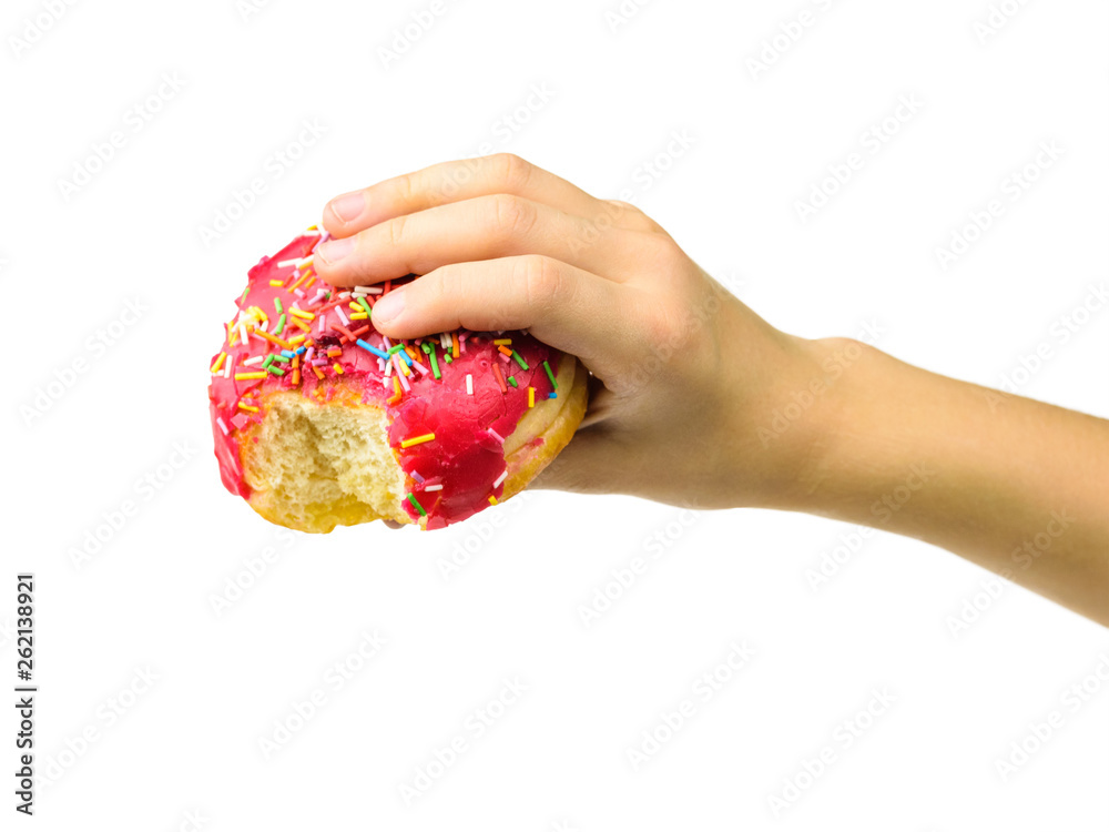A pink doughnut in the hand of a child with a bitten-off edge isolated on white background. A pink doughnut in the hand of a child with a bitten-off edge isolated on white background.