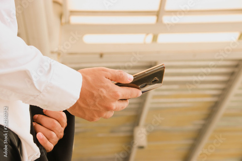 Businessman standing using a smartphone to schedule an appointment in the work.
