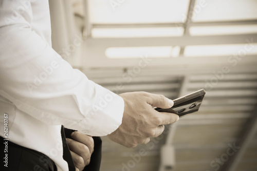 Businessman standing using a smartphone to schedule an appointment in the work. © kangwan