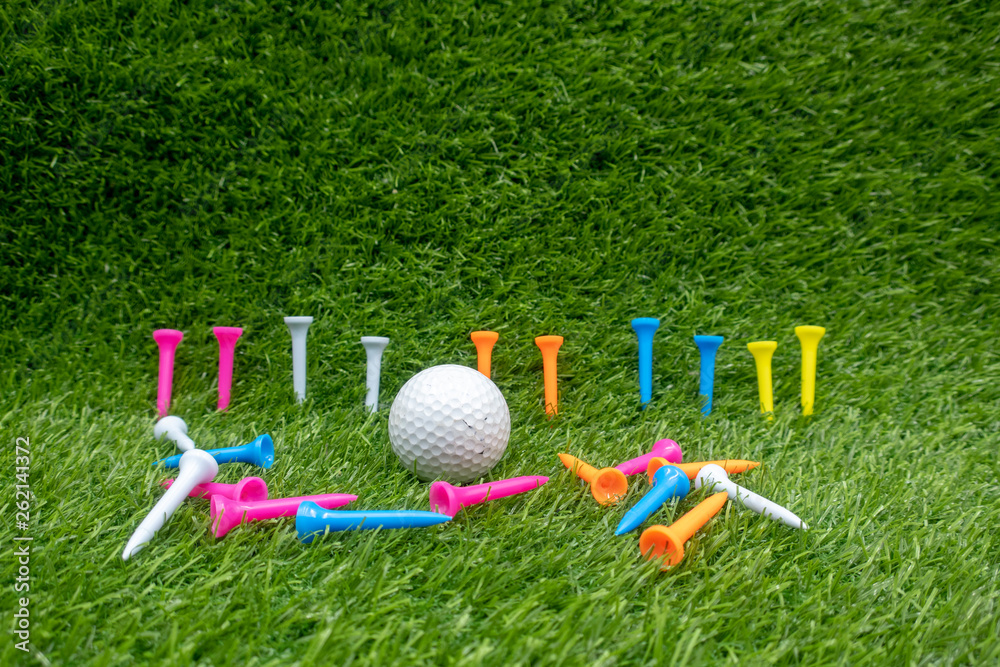 Naklejka premium Golf ball with colourful tees are on green grass