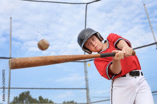 Canvas Print Young batter hitting the ball in a youth Baseball game