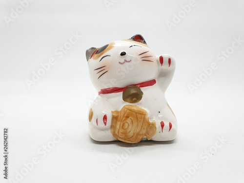 Porcelain Cat Statue representing luck symbol and sign for traditional chinese culture presented in white isolated background © Yudhistira