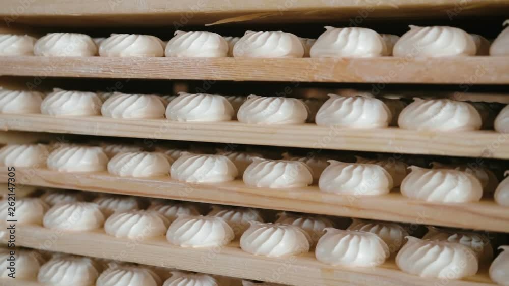 Panorama of many sweets white marshmallows stored in wooden racks in the warehouse of the confectionery factory. The concept of ready-made sweet products Panorama of many sweets white marshmallows stored in wooden racks in the warehouse of the confectionery factory. The concept of ready-made sweet products