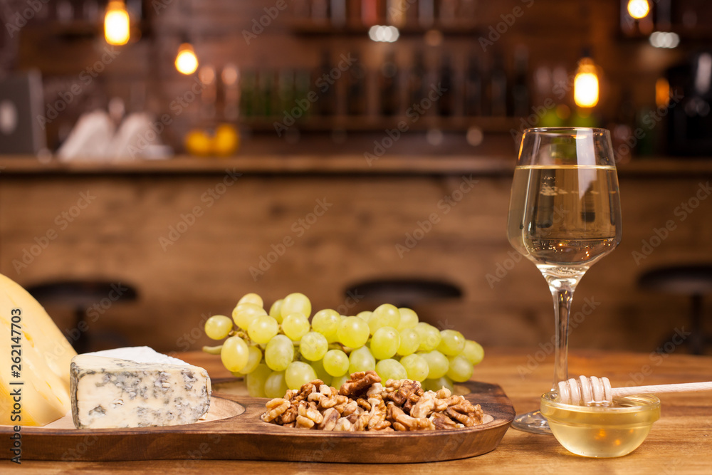 Food composition with varisious snacks for white wine on a wooden table. Food composition with varisious snacks for white wine on a wooden table.