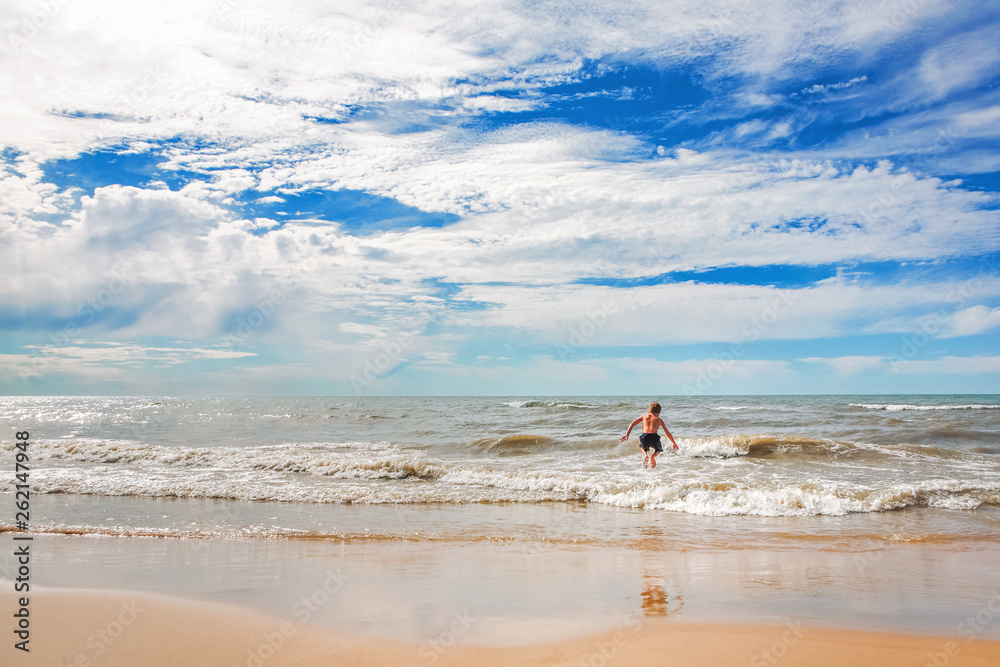 Boy jumping in the waves at the beach
