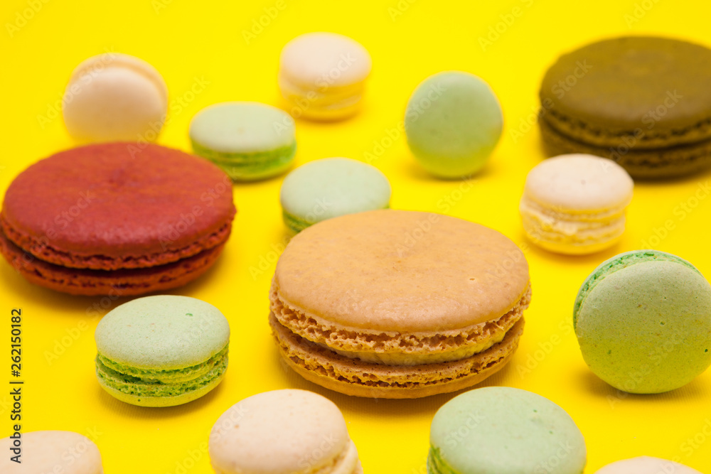 Luxury french macaroons dessert over yellow background Luxury french macaroons dessert over yellow background