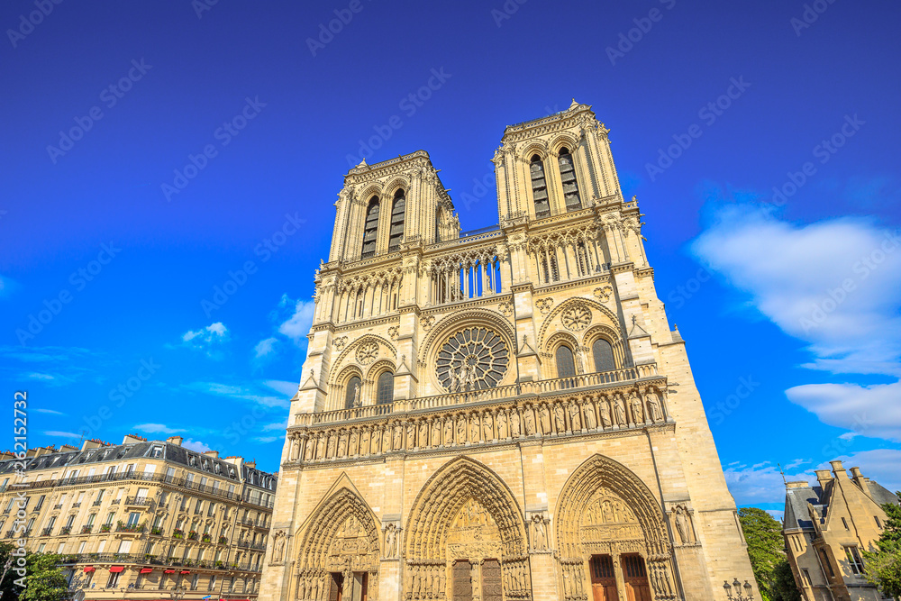 Details of French architecture of Notre Dame cathedral of Paris, France. Beautiful sunny day in the blue sky. Our Lady of Paris church. Central main facade with towers and gothic rosettes.