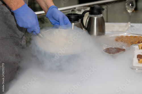 Fascinating process of preparation of ice cream with use of dry ice in wafer cups.