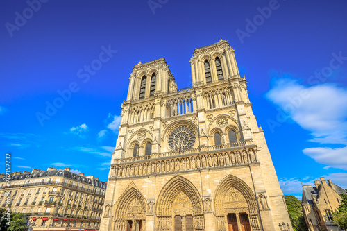 Details of French architecture of Notre Dame cathedral of Paris, France. Beautiful sunny day in the blue sky. Our Lady of Paris church. Central main facade with towers and gothic rosettes.