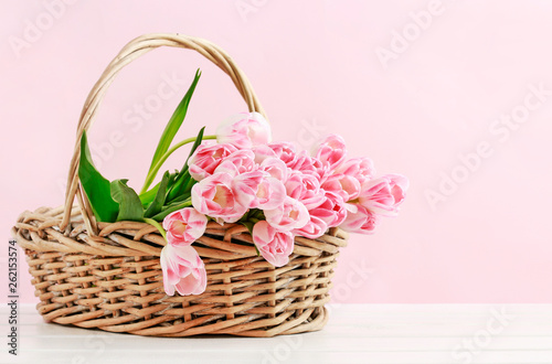 Huge bouquet of pink tulips in wicker basket. Postcard motif