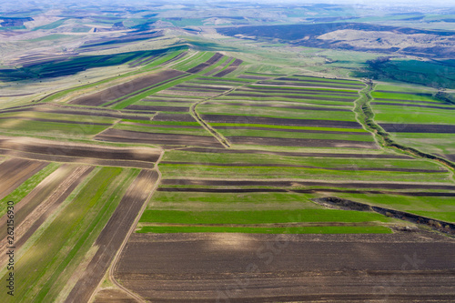 Aerial drone view of agricultural fields of plowed crops