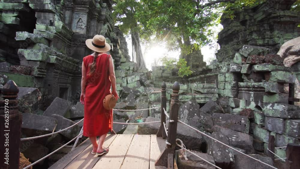Picturesque view of woman enjoying ruins and tower of famous Ta Prohm temple (Angkor Wat complex) in Cambodia. Beautiful sunny day Picturesque view of woman enjoying ruins and tower of famous Ta Prohm temple (Angkor Wat complex) in Cambodia. Beautiful sunny day