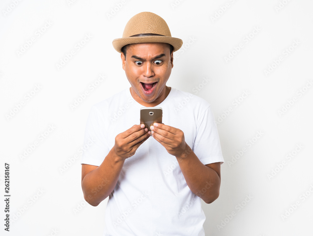 Surprised and shocked asian man looking smartphone Surprised and shocked asian man looking smartphone