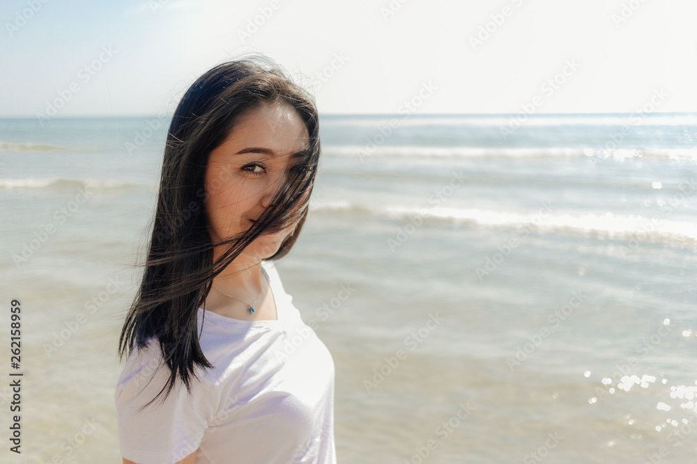 Woman walking along the beach under the sunny day of summer. Woman walking along the beach under the sunny day of summer.