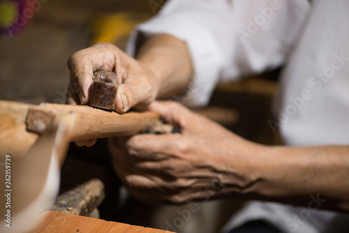 Obraz na plátně adult master restores old musical instruments. wood carving