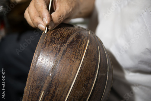 Obraz na plátně adult master restores old musical instruments. wood carving