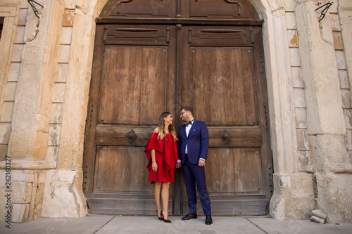In love wedding couple posing outdoor in front of old castle wooden gate © hreniuca