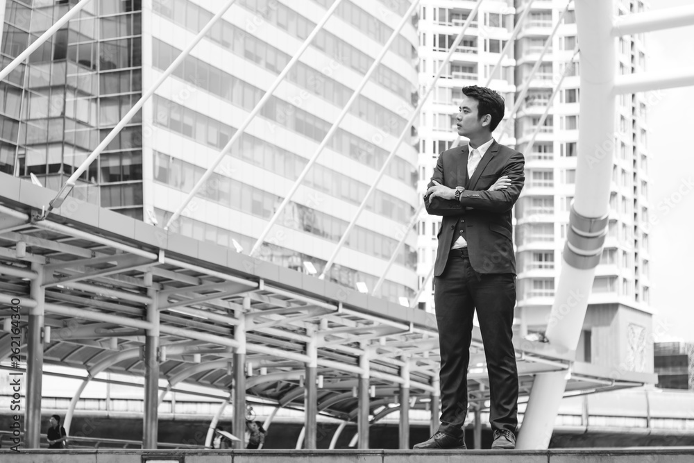 Young businessman in blue suit standing outdoor in the city. Black and white Young businessman in blue suit standing outdoor in the city. Black and white