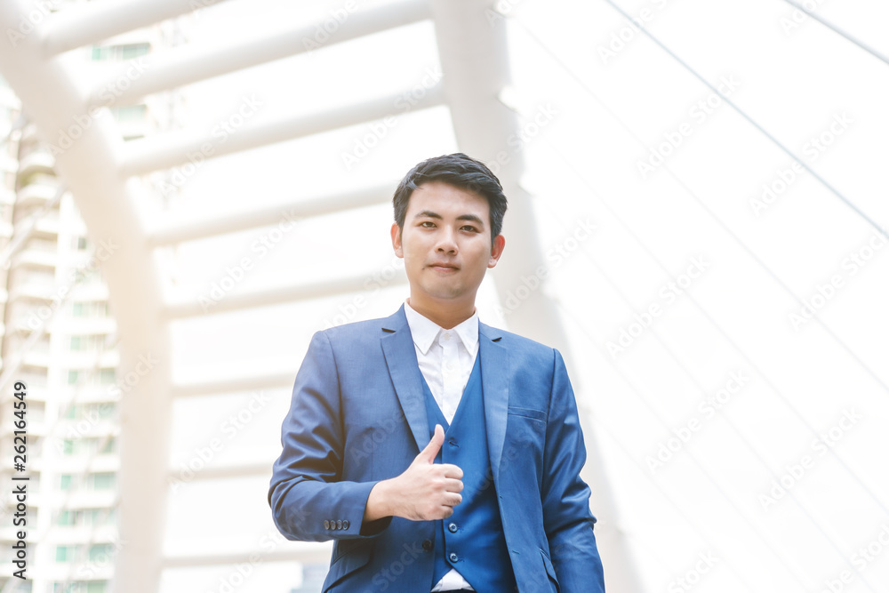 Young handsome businessman in blue suit shows thumbs up. Young handsome businessman in blue suit shows thumbs up.