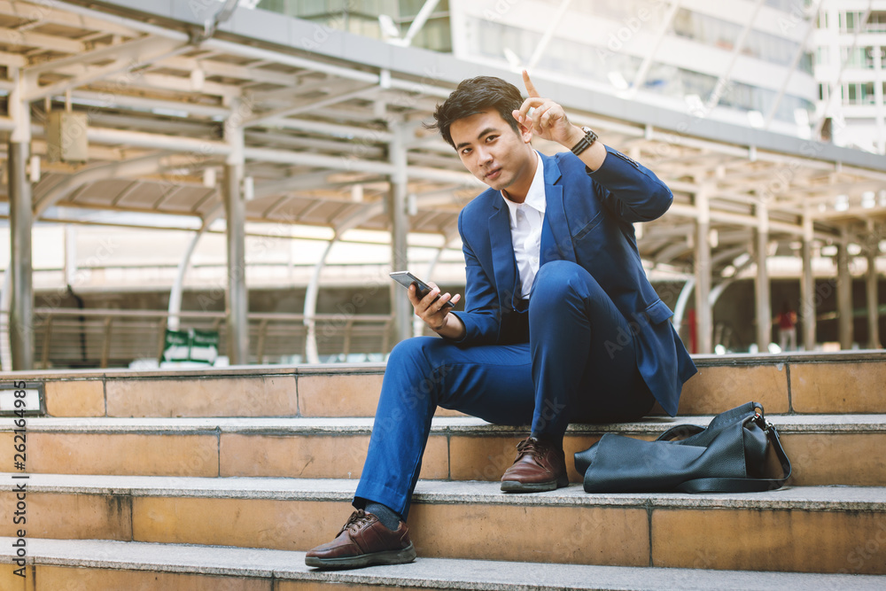 Young handsome businessman pointing finger and carry mobile phone, success businessman concept.