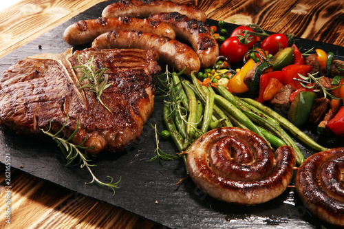 Fotografie Assorted delicious grilled meat with vegetable on a barbecue with steak