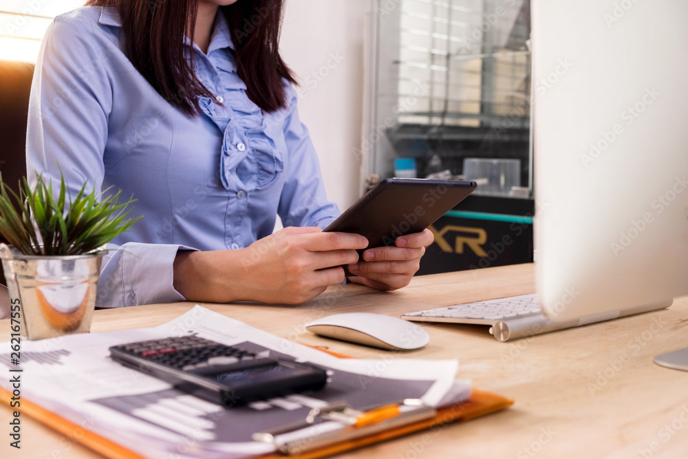 Business documents on the desk with a laptop and a laptop with graphs, business diagrams and women working in the office. Business documents on the desk with a laptop and a laptop with graphs, business diagrams and women working in the office.