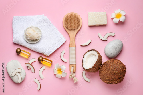 Composition with spa stones, coconut oil, soap and brush on color background