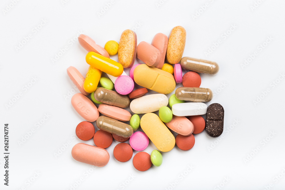 set of multi-colored tablets and capsules on a white background set of multi-colored tablets and capsules on a white background