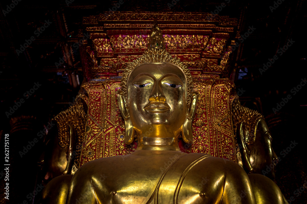 Fototapeta premium closeup gold buddha statue in thai lanna temple with soft-focus and over light in the background, Chiang Rai Province, Thailand