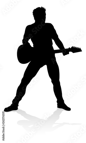 A guitarist musician in detailed silhouette playing his guitar musical instrument.